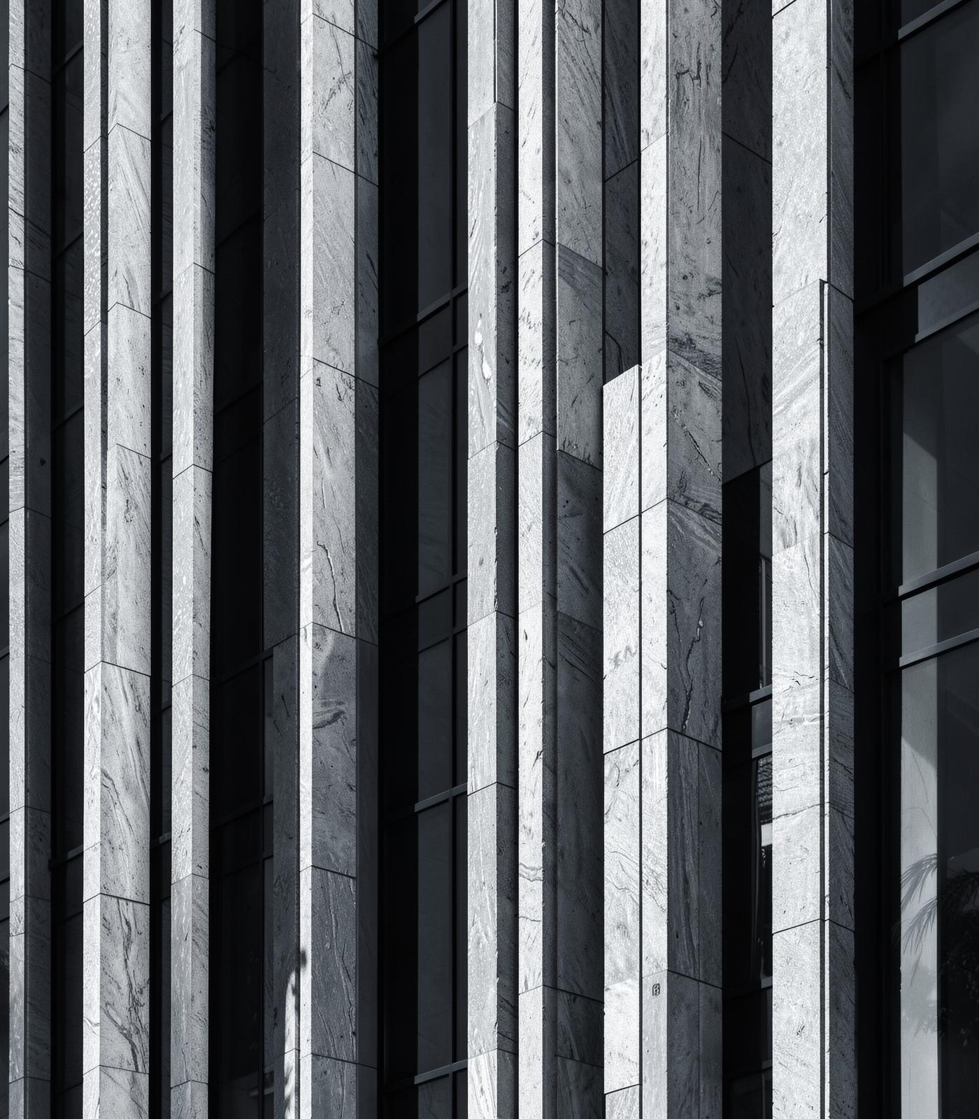 Vertical stone fins and glass on a modern building facade