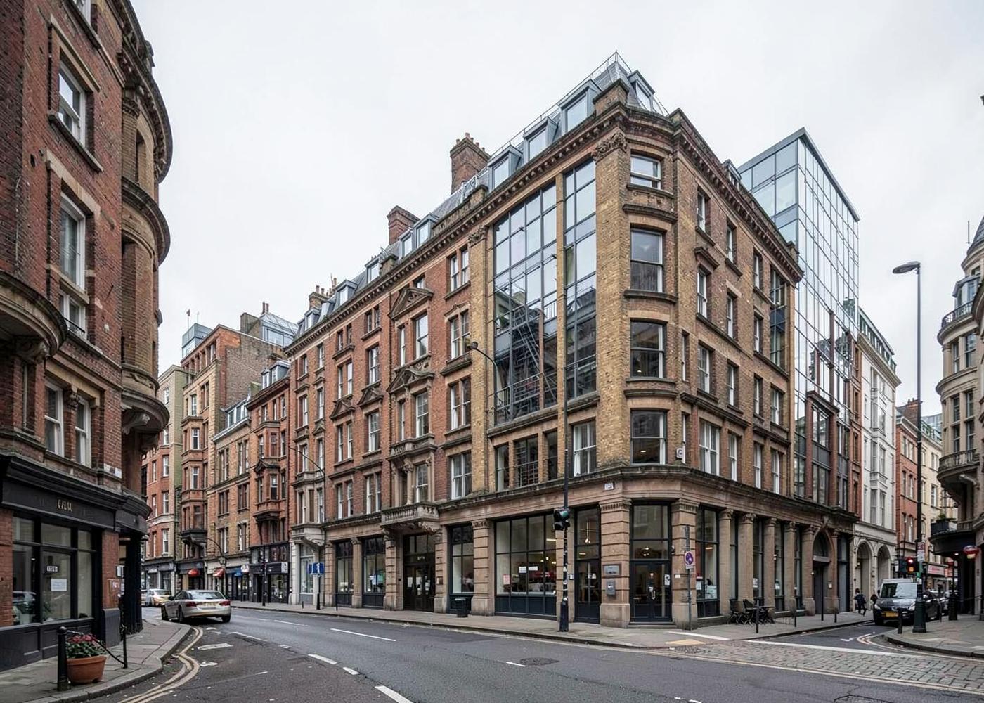 A street of Victorian brick commercial buildings with a modern glass extension